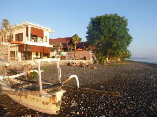 a boat sitting on a beach next to a house at Casa De Amed in Amed