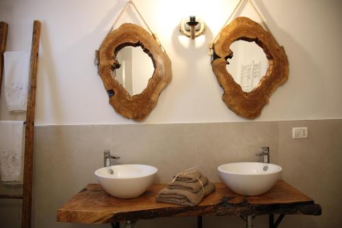 a bathroom with two sinks and two mirrors on the wall at CasaVacanza nonna Vita in Locorotondo