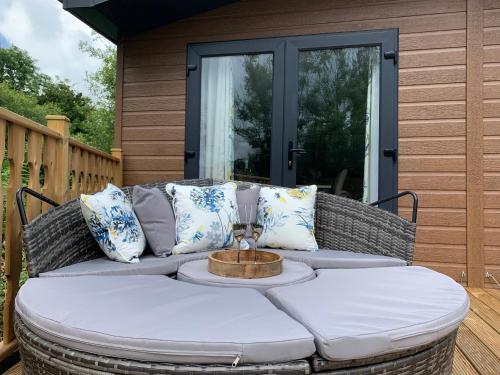 a wicker couch on a porch with a table at Coniston View 7 in Warton