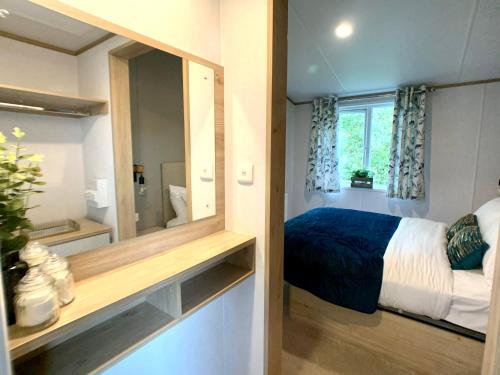 a small bedroom with a bed and a mirror at Coniston View 7 in Warton