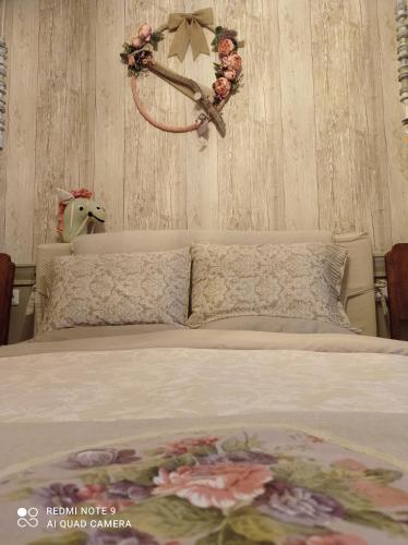 a bedroom with a bed with a flower wreath on the wall at 1957 To Rodo kai to Roido in Karpenision