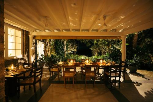 a patio with a table and chairs under a pavilion at Glenross Living - A Collection of 7 Private Pool Villas and 3 Colonial Suites in Kalutara