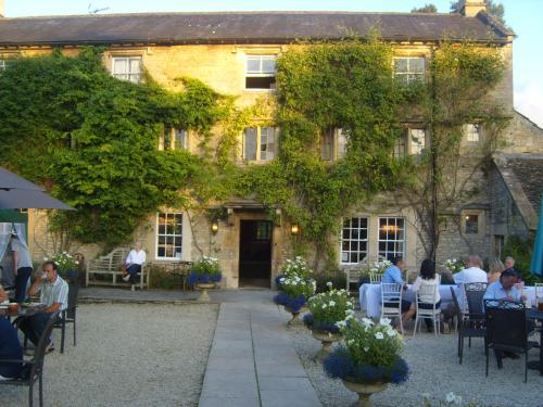 a group of people sitting at tables in front of a building at Guyers House Hotel and Restaurant in Corsham