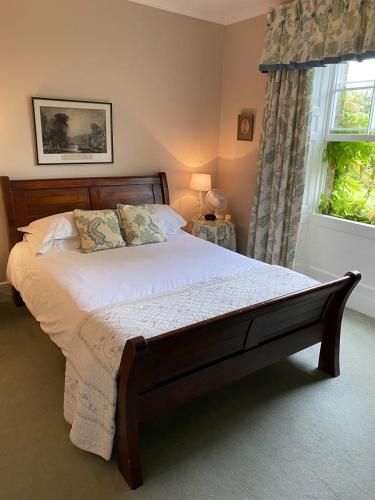 a large bed in a bedroom with a window at Guyers House Hotel and Restaurant in Corsham