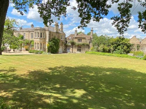 a large house with a large lawn in front of it at Guyers House Hotel and Restaurant in Corsham