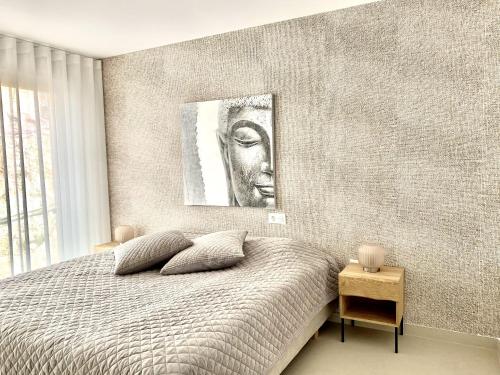 a bedroom with a bed with a picture on the wall at Stupa Hills - Superb Luxury Apartment Sea Views in Benalmádena