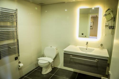 a bathroom with a toilet and a sink and a mirror at Hotel Perce Neige in Ifrane