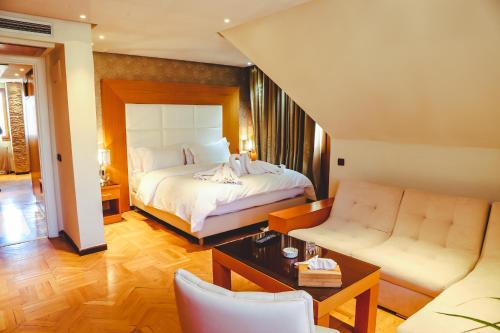 a bedroom with a bed and a living room at Hotel Perce Neige in Ifrane