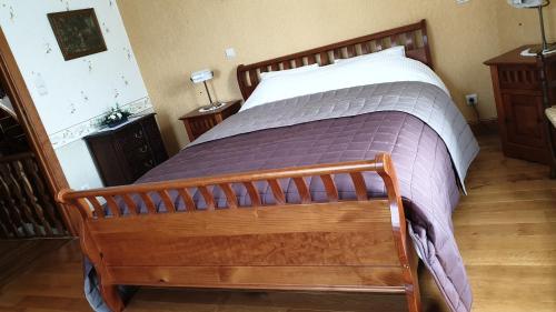 a bedroom with a large bed with a wooden frame at Le Prangeleux in Tenneville