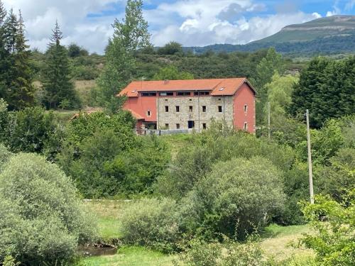 Ein altes Gebäude mitten auf einem Feld in der Unterkunft Casa Rural Molino de Luna in Soncillo