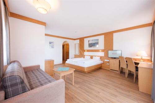 a living room with a bed and a dining room at Der Waldhof in Scheffau am Wilden Kaiser