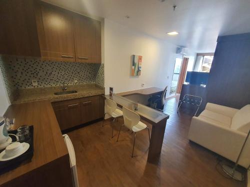 a kitchen and living room with a table and a couch at Flat Nobile Suítes Monumental By Rei dos Flats, in Brasilia