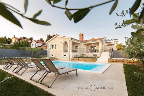 eine Villa mit einem Pool und einem Haus in der Unterkunft Villa Carolina in Izola