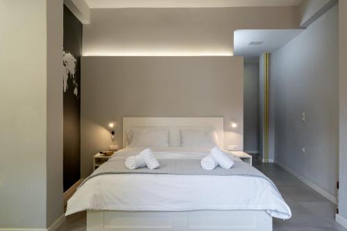 a bedroom with a large white bed with two pillows at Petit Keramikos Studio - Historic Center in Athens