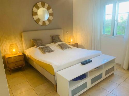 a bedroom with a white bed with a mirror on the wall at Sea Front Apartment Orient Bay in Orient Bay French St Martin