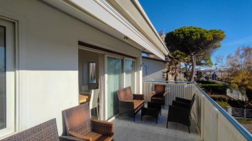 a balcony with chairs and tables on a building at Villa Miami in Bibione