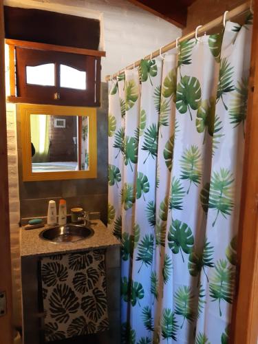 a bathroom with a shower curtain with a sink at Cabañas Farah Estancia Vieja ideal para 2 a 3 huéspedes in Villa Carlos Paz
