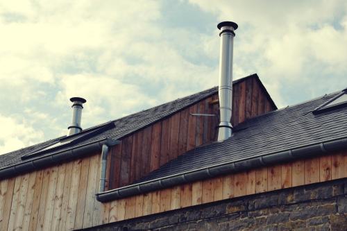 a roof of a building with smoke stacks on it at La petite Reuleau - Gites champêtre "LE FENIL" et "LA FERMETTE SAUNA " in Ciney