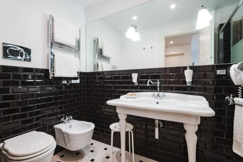 a bathroom with a white sink and a toilet at Nikis Collection Trastevere in Rome