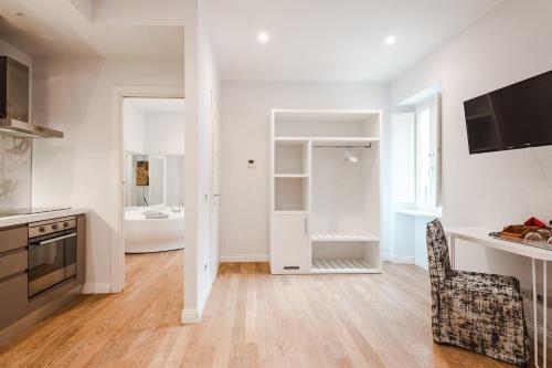 a kitchen with white walls and wooden floors at Nikis Collection Trastevere in Rome