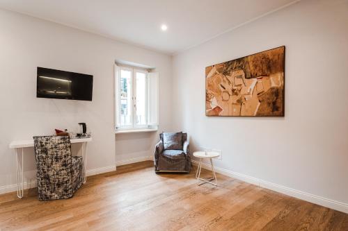 a living room with a chair and a painting on the wall at Nikis Collection Trastevere in Rome