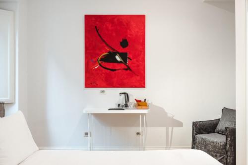 a room with a table and a red painting on the wall at Nikis Collection Trastevere in Rome