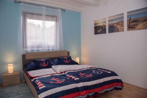 バラトンベレーニにあるHoliday home Balatonbereny/Balaton 18044のベッドルーム1室(赤いクリートが付いたベッド1台付)