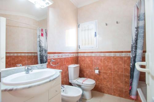 a bathroom with a white toilet and a sink at Villa La Martina - PlusHolidays in Calpe