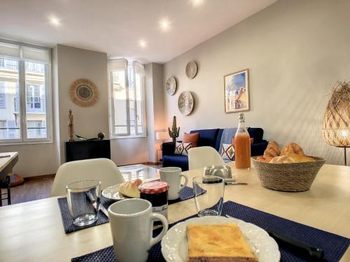 un salon avec une table avec de la nourriture dessus dans l'établissement Nestor&Jeeves - CACTUS RIVIERA - Hyper center - Very close sea and Place Massena, à Nice