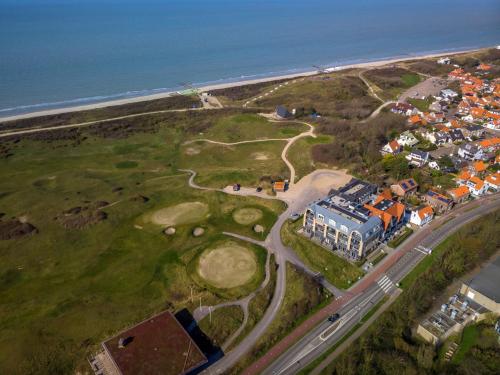 uma vista aérea de um campo de golfe junto ao oceano em Residence Ruimzicht - Baddomburg em Domburg