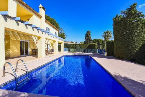 a swimming pool in front of a house at Villa Gio - PlusHolidays in Calpe