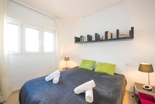 una camera da letto con un letto con due cuscini sopra di Apartamento Felicidad - PlusHolidays a La Canuta