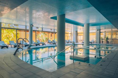 a swimming pool in a building with tables and chairs at Iberostar Waves Gaviotas Park in Morro del Jable