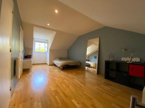 Cette grande chambre dispose d'un lit et de parquet. dans l'établissement Une belle chambre au calme avec piscine, à Ormesson-sur-Marne