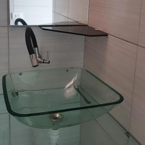 ein Glaswaschbecken mit einem Wasserhahn im Bad in der Unterkunft Suíte praia de leste in Pontal do Paraná