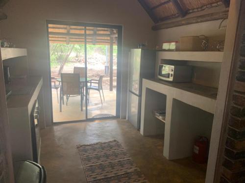 a kitchen with a door to a patio with a table at Athule Inn Marloth - Units in Marloth Park