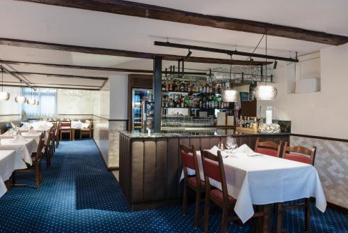 a dining room with tables and a bar at Hotel & Restaurant Rössli in Stansstad