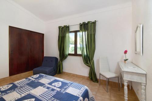 a bedroom with a bed and a desk and a window at Vila Filipa in Guia
