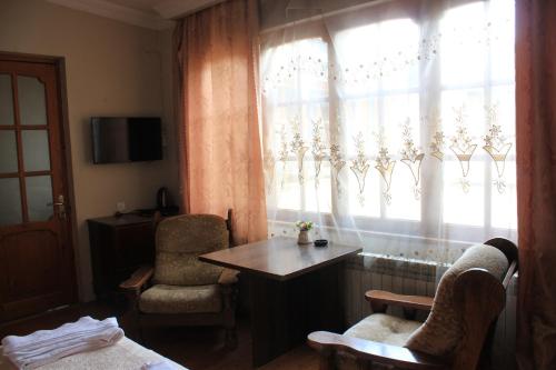 una camera con finestra, tavolo e sedie di Valiko a Tbilisi City