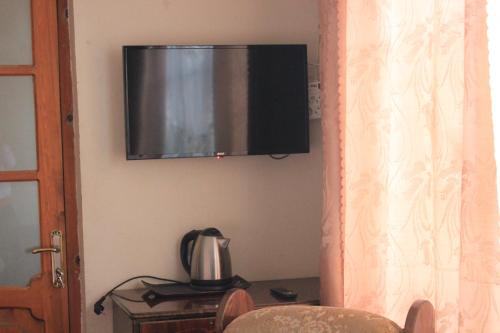 une télévision accrochée au mur avec une bouilloire dans l'établissement Valiko, à Tbilissi
