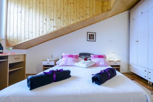 una camera da letto con un grande letto bianco con cuscini rosa di Apartment Matic a Dubrovnik