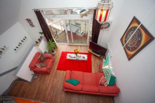 een woonkamer met een rode bank bij Special 3 Bedroom Townhouse With Parking in Bristol in Bristol