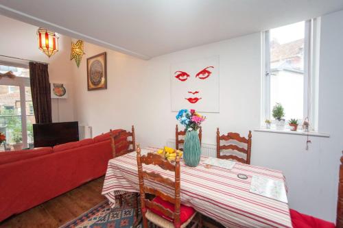 een woonkamer met een rode bank en een tafel bij Special 3 Bedroom Townhouse With Parking in Bristol in Bristol