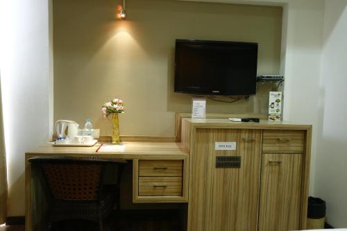 a room with a desk with a television on a wall at Hotel City Centre Residency in Bengaluru