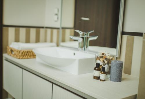 a bathroom counter with a sink and a mirror at Grand Baltic Dunes Hotel & SPA in Palanga