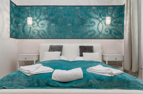 - une chambre avec un lit bleu et 2 chaises dans l'établissement P43 Judi Apartment, à Budapest