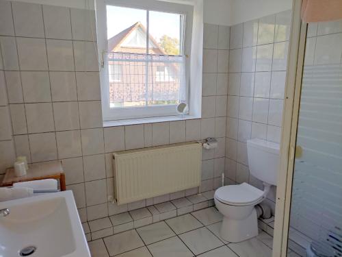 a bathroom with a toilet and a window at Ferienwohnung Gisela Rohde in Bad Bramstedt
