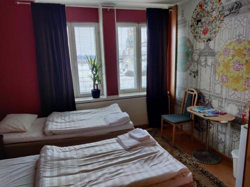 a hotel room with two beds and a window at Hotelli Merikotka in Kotka