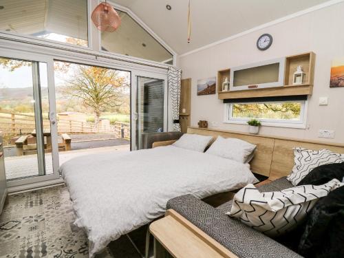 a bedroom with a large bed and a couch at Oak Tree View in Rhayader