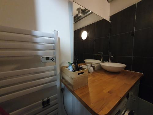 La salle de bains est pourvue d'un comptoir en bois et d'un lavabo. dans l'établissement Studio design proche Défense-Paris, à Rueil-Malmaison